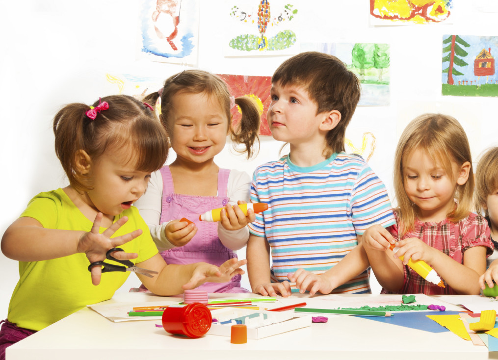 Many kids drawing and gluing